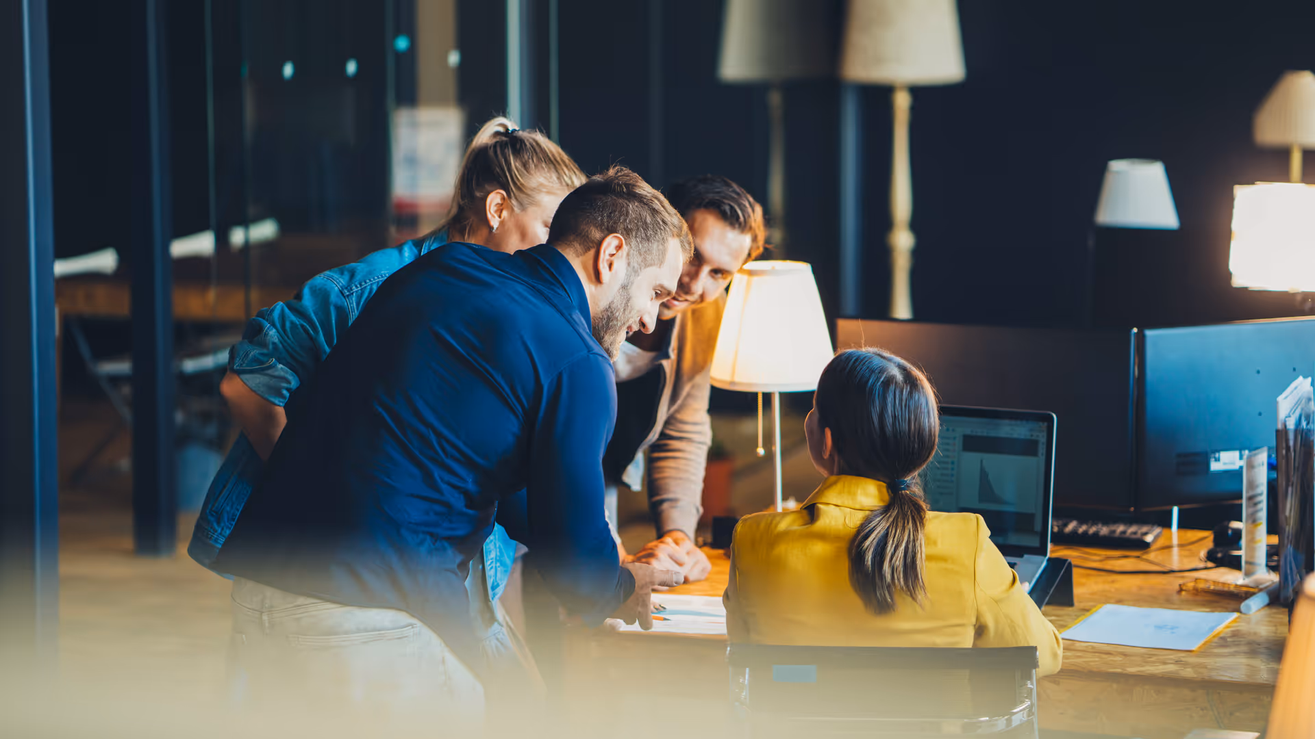 Team arbeitet gemeinsam an einem Schreibtisch in einer modernen Büroumgebung – im Fokus stehen Innovationskraft am Arbeitsplatz, Teamarbeit und Projektplanung.