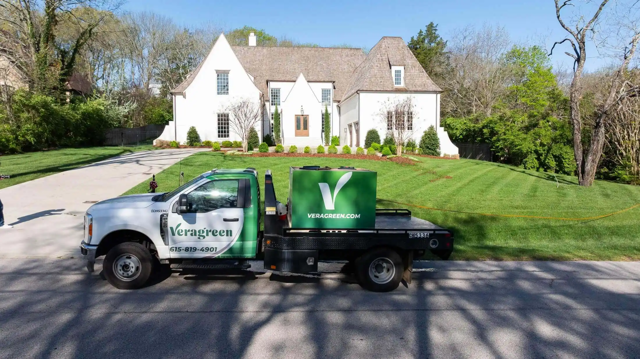 Veragreen service truck parked at residential home with maintained lawn and landscaping