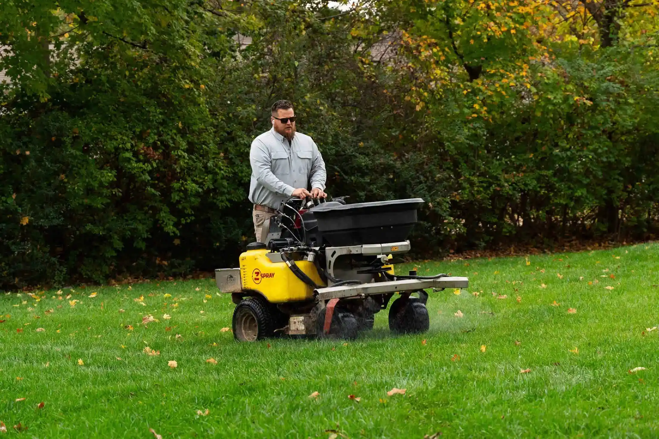 Veragreen technician operating professional lawn maintenance equipment on healthy green lawn