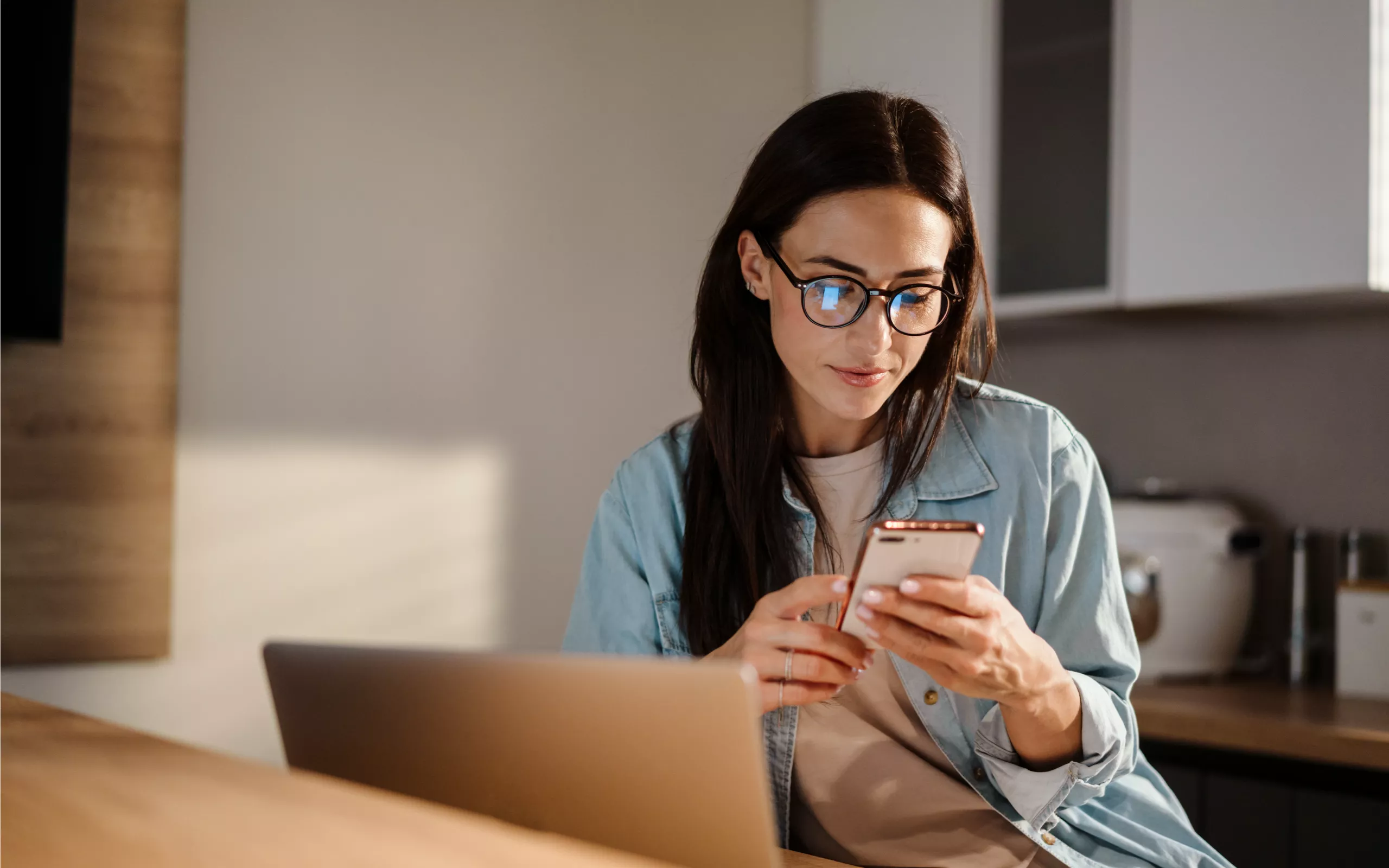 Eine Frau hat einen schwarzen Ordner und ein Handy in den Händen
