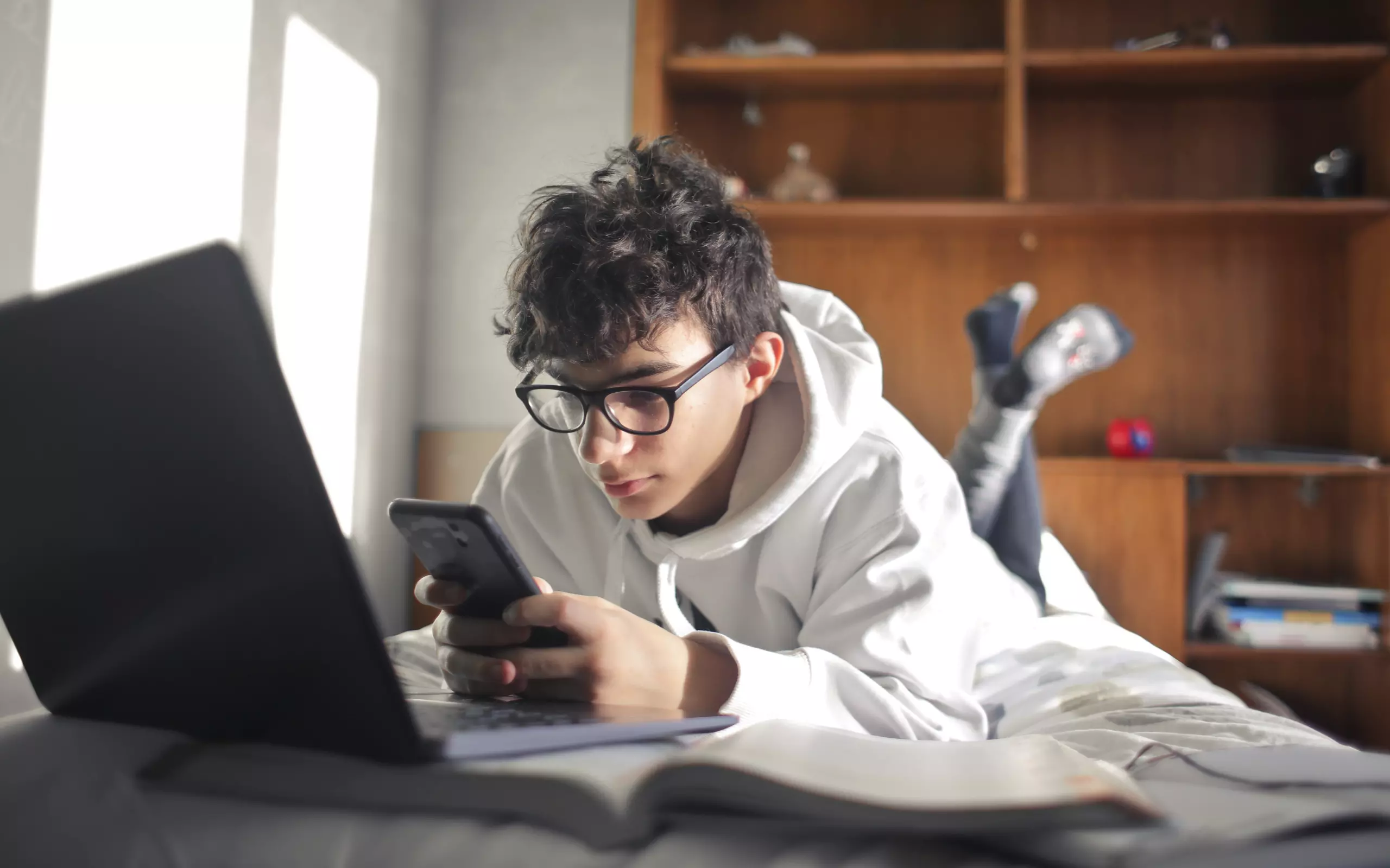 3 Kinder schauen zusammen in ein Handy