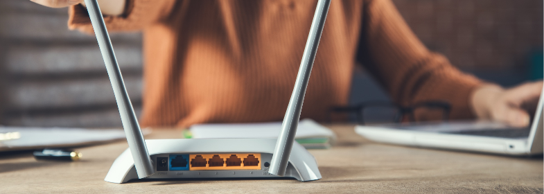 Router im Wohnraum mit angedeuteten WLAN-Signalwellen.