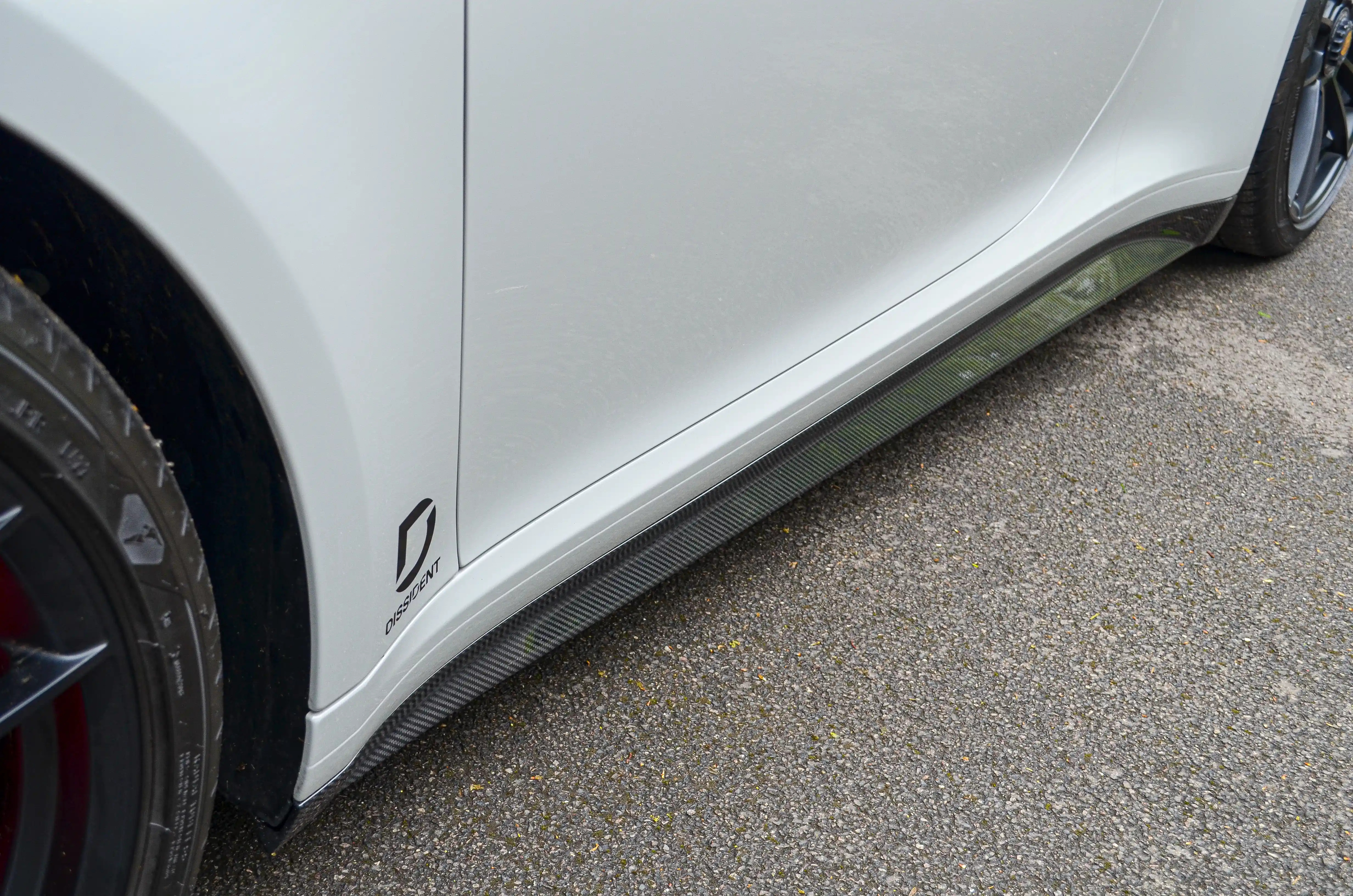 Dissident carbon fibre side skirt fitted along the rocker panel of a Porsche 992