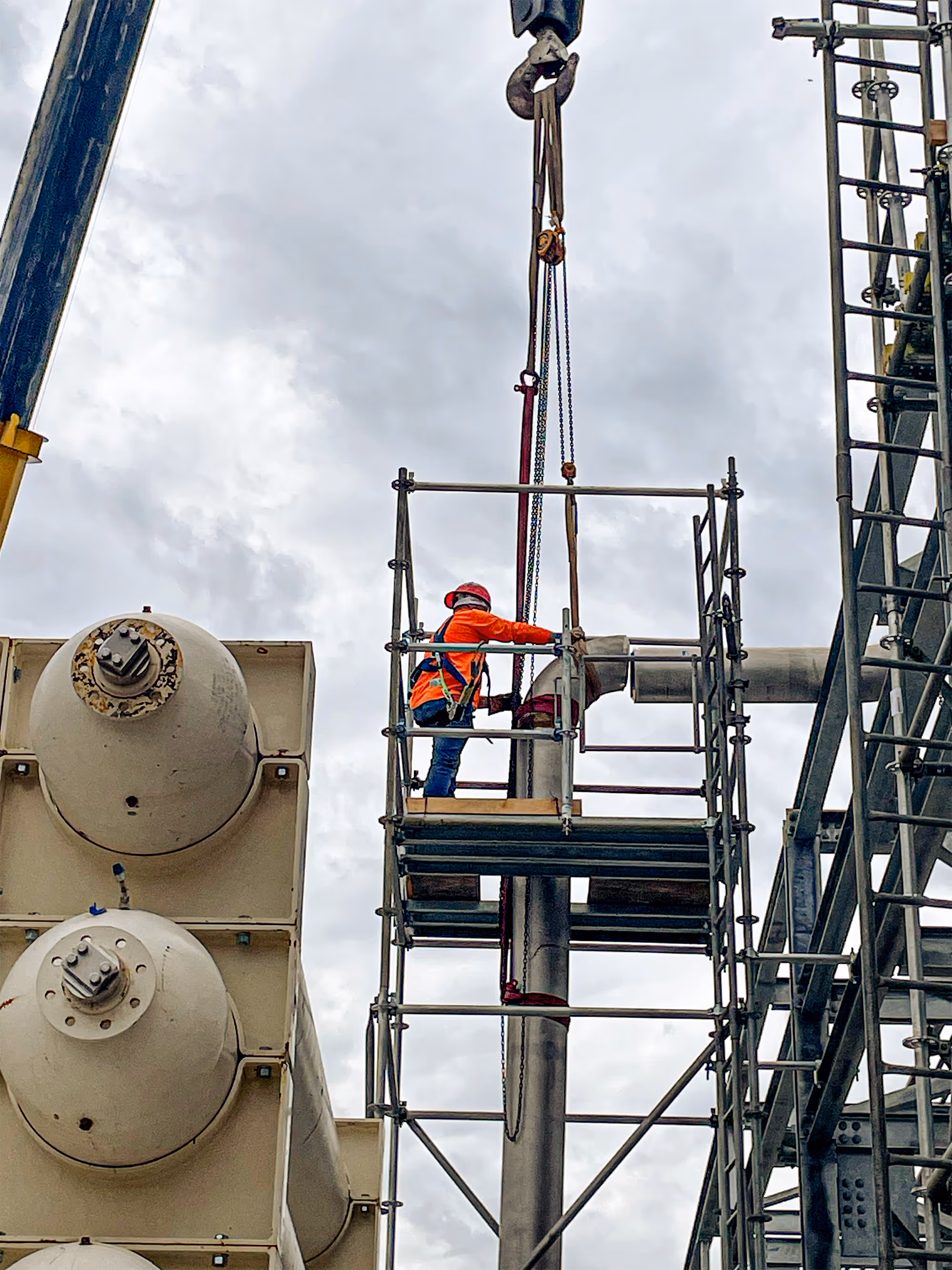 A Freitag-Weinhardt employee is working to install a section of process piping at a job site