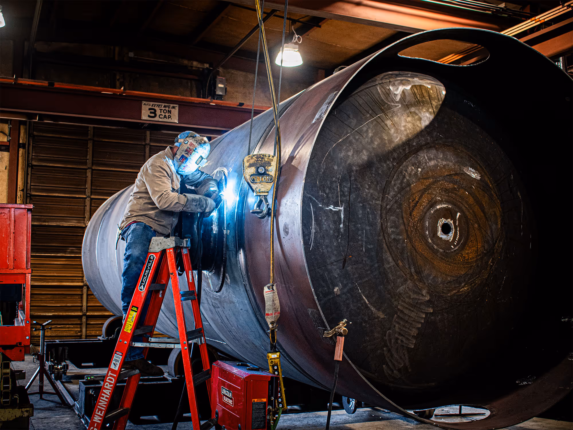 A Freitag employee welding together a vessel for a job site.