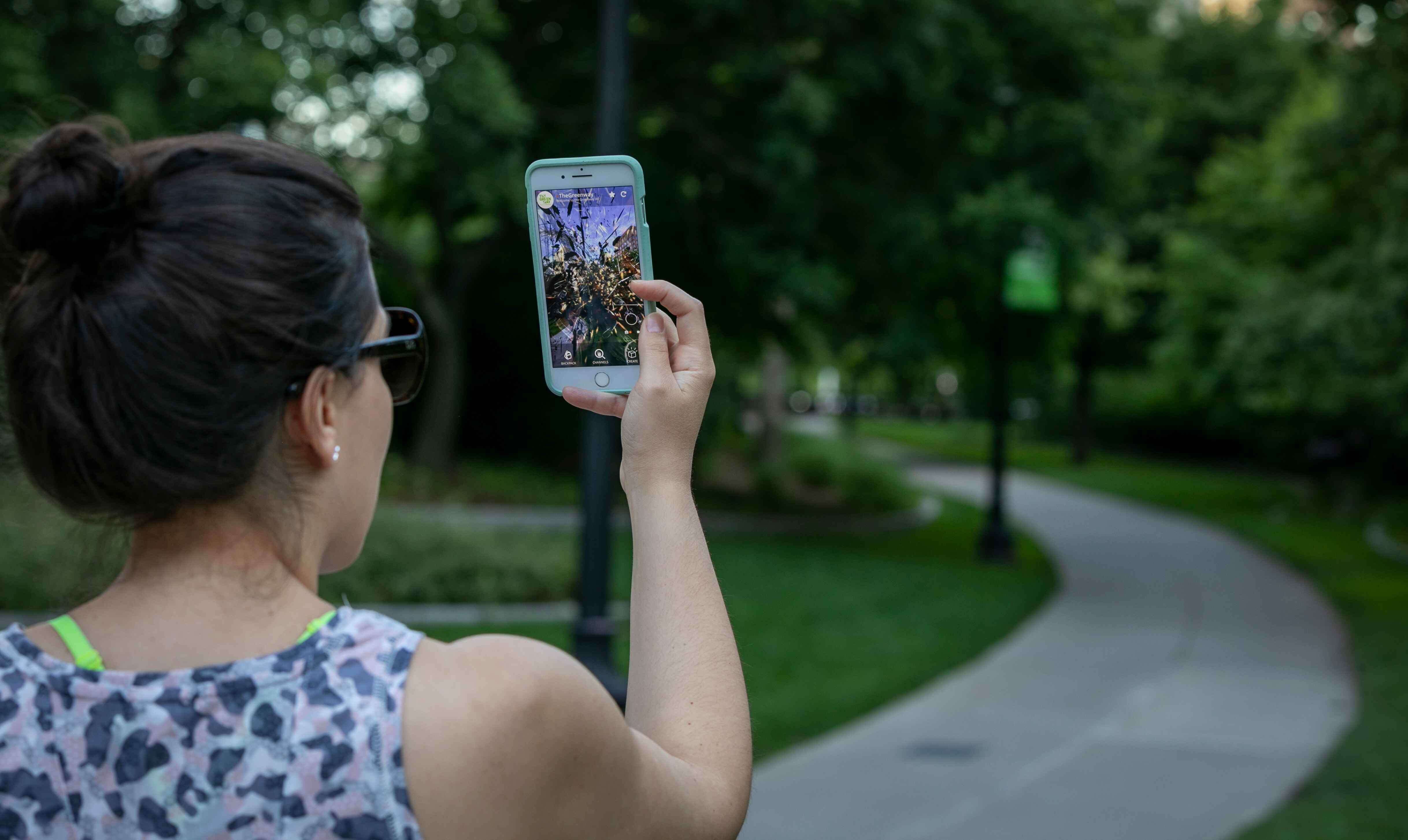 User on thier phone experiencing greenway AR exhibit in boston