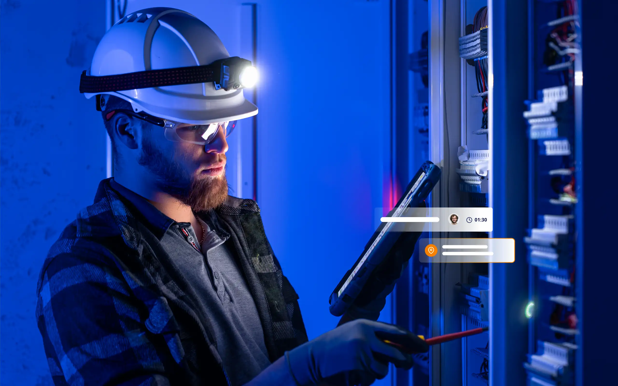 Techniker arbeitet an Schaltschrank mit Tablet zur digitalen Dokumentation und Standorterfassung im Außendienst