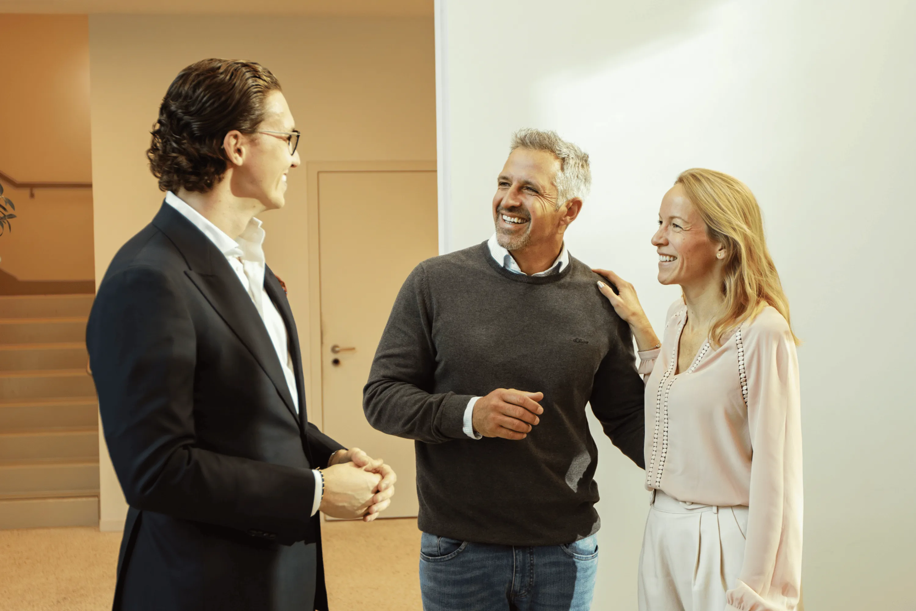 Matthias Nussbaumer lächelt einen Kunden an und sitzt mit ihm auf einen Schreibtisch im Büro