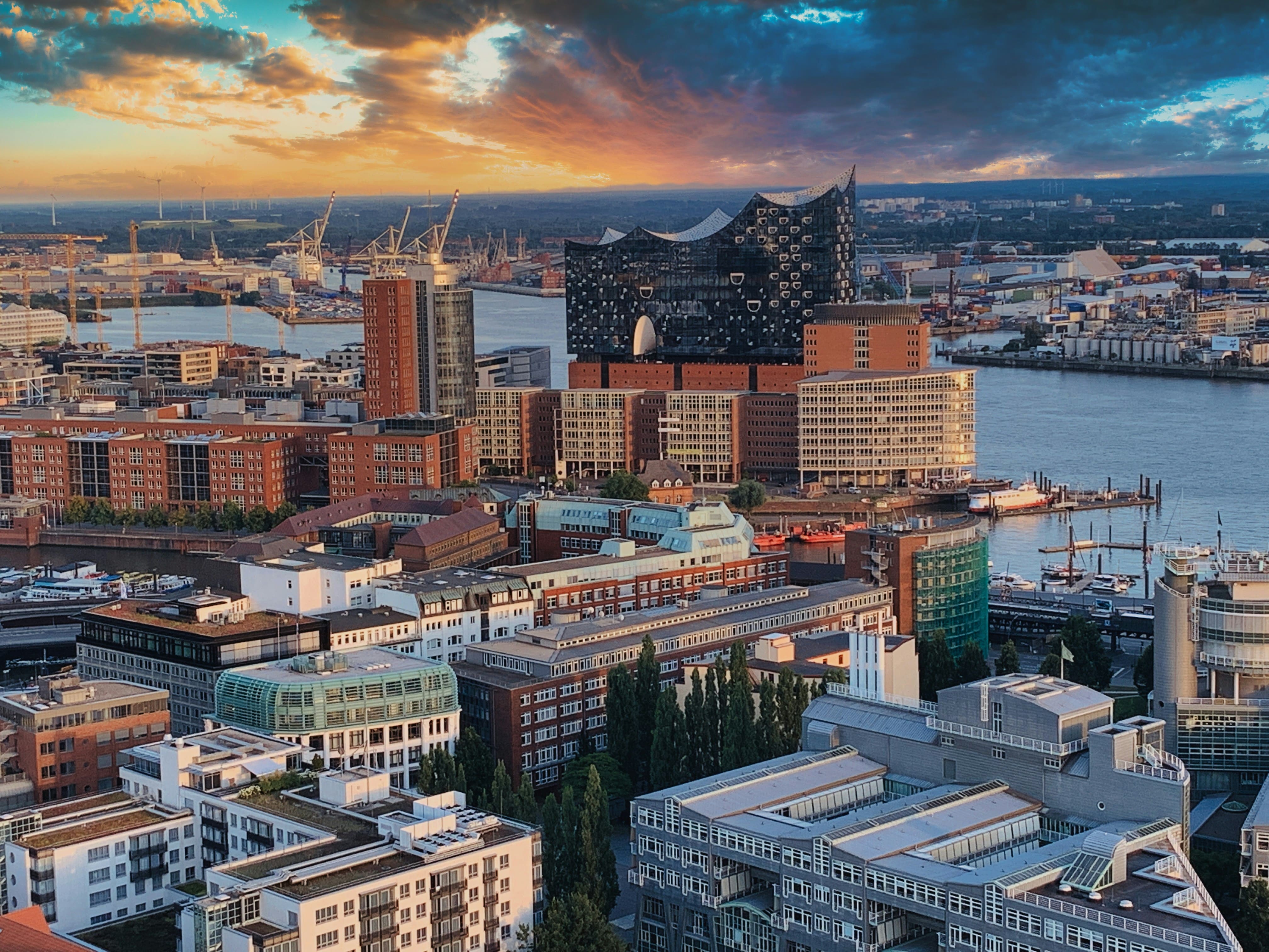 Panoramablick auf Hamburg mit der Elbphilharmonie bei Sonnenuntergang und Hafen im Hintergrund.