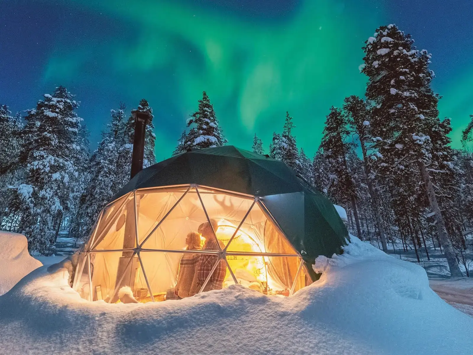 Northern Lights over glass igloos in Lapland