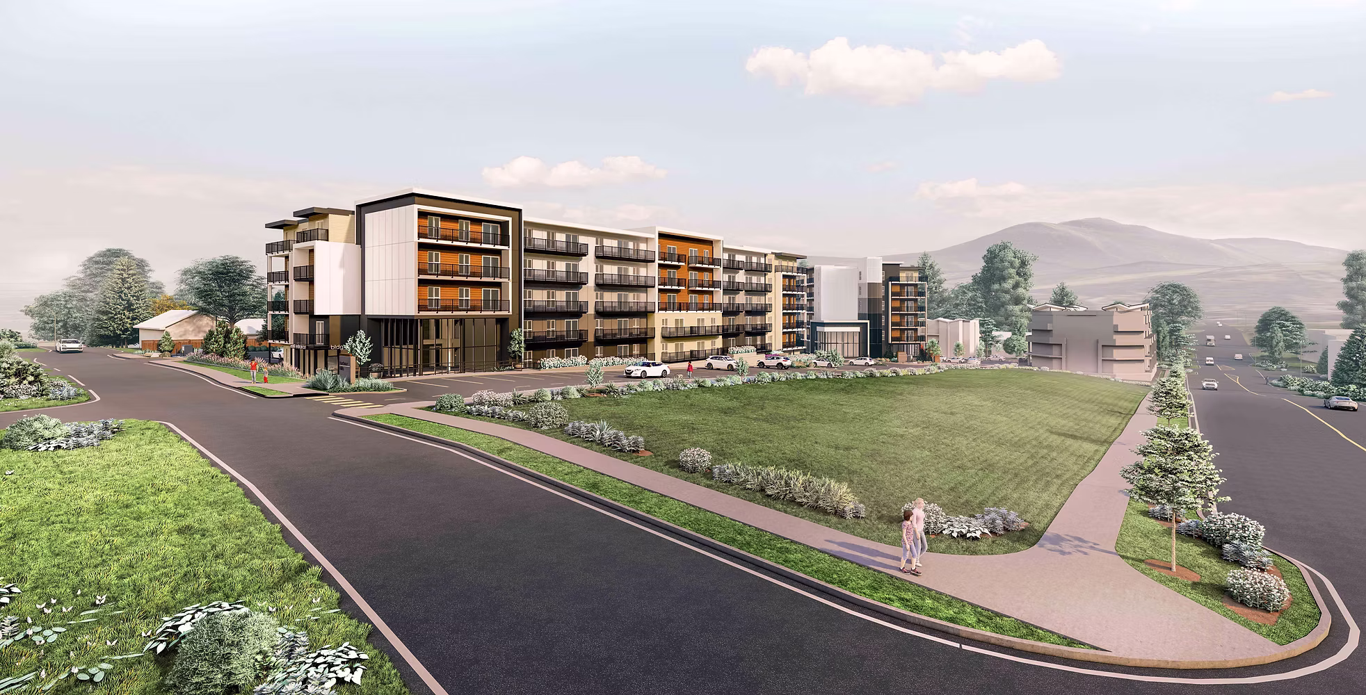 Modern apartment complex with landscaped roads and mountain backdrop