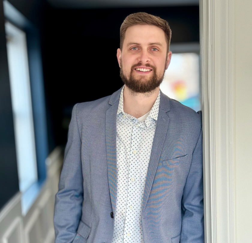 Professional man in business attire. Design and Engineering works display visible behind.