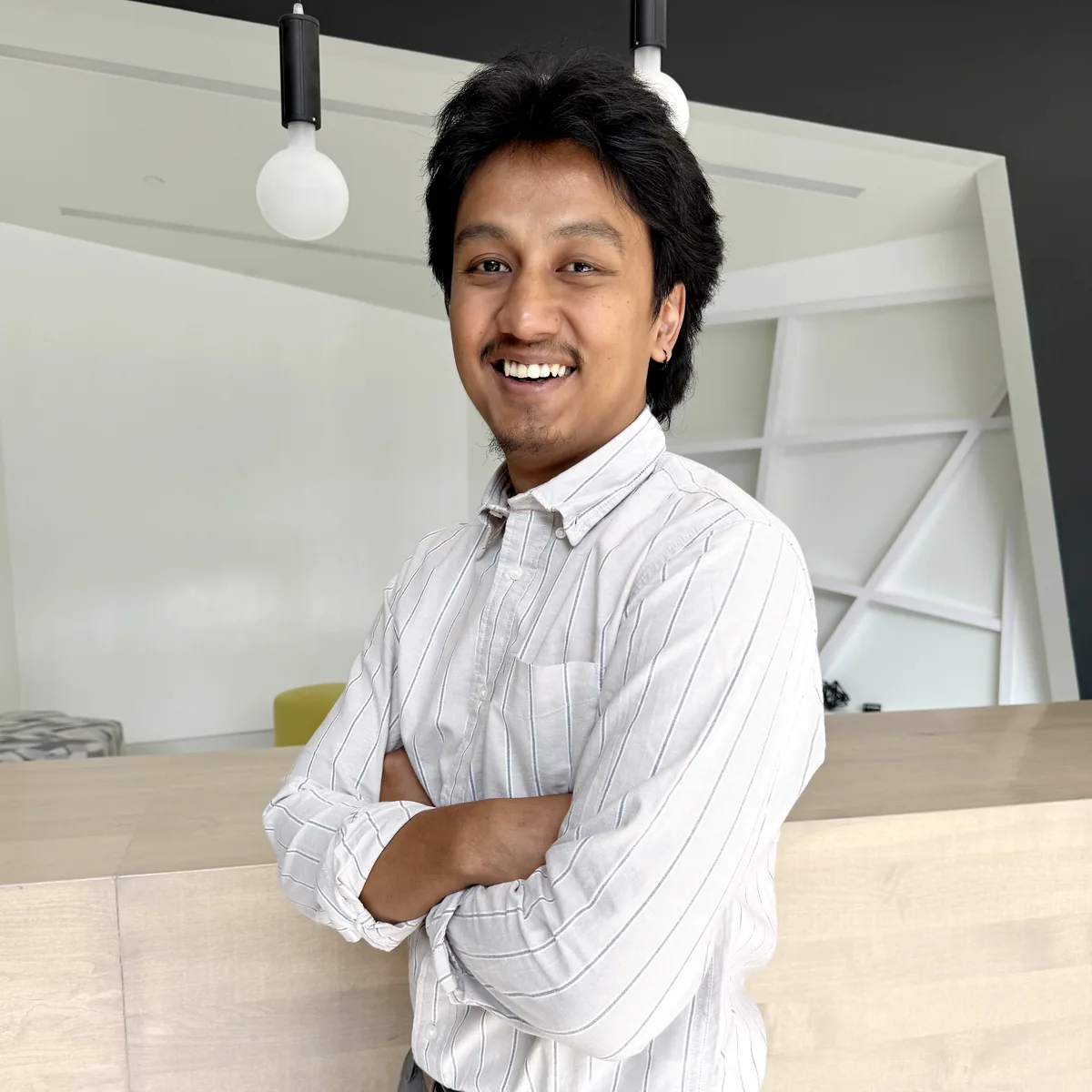 Professional Design engineer Works in modern office with confident smile and crossed arms