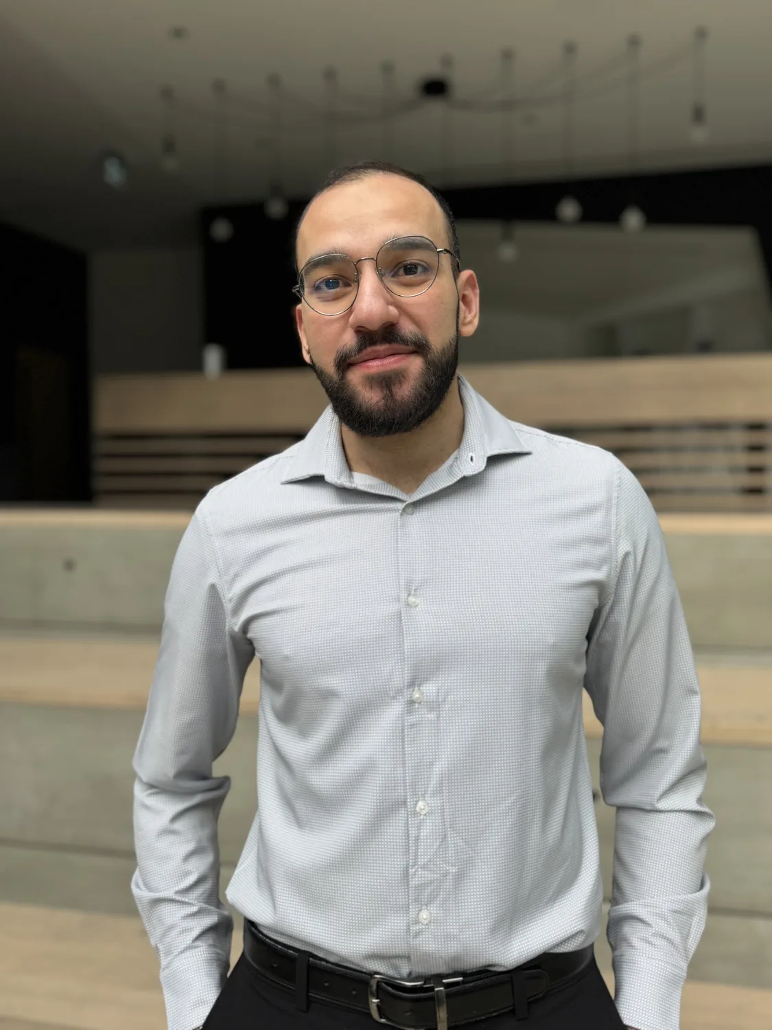 Professional man in glasses poses in modern space where engineering design works showcase innovation