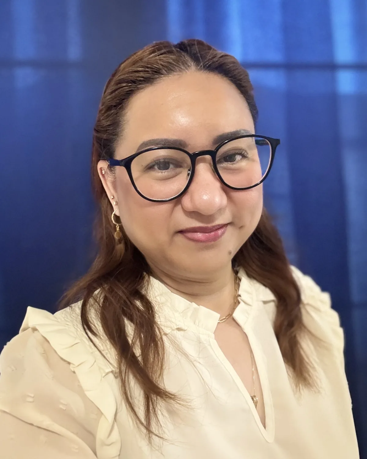 Professional woman in design and engineering works wearing glasses and cream blazer