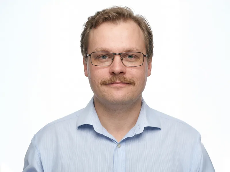 Professional headshot of engineer wearing glasses. Design works engineering expertise portrait.