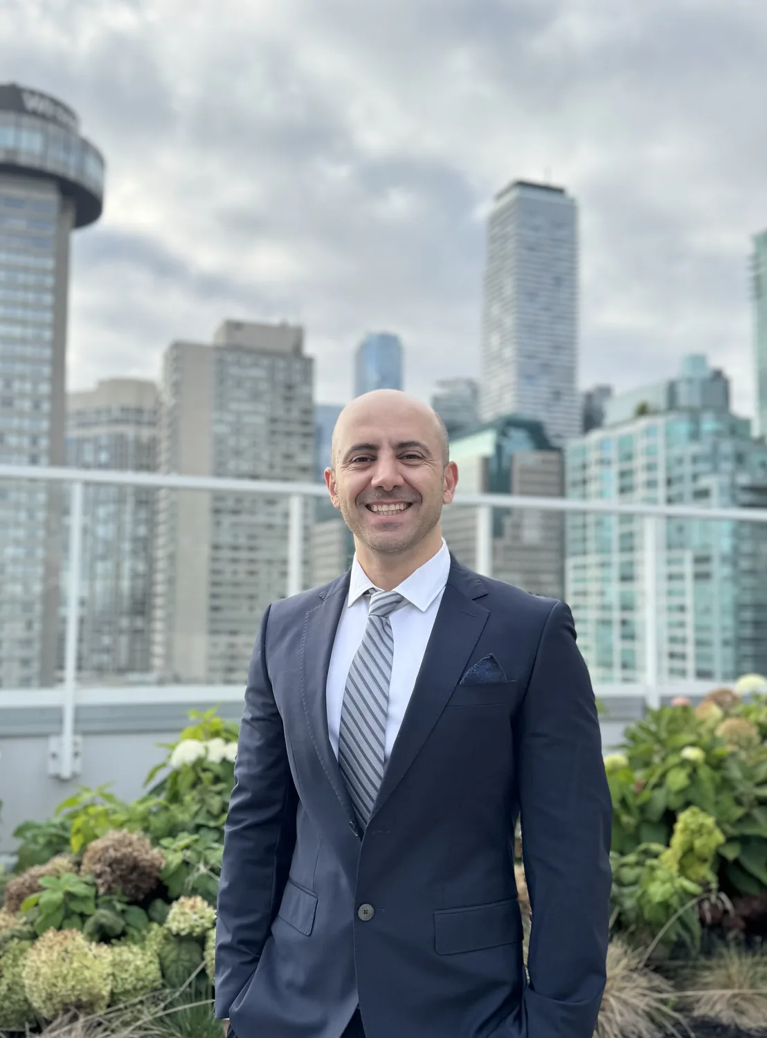 Professional man in suit on rooftop, Design Works Engineering skyline background