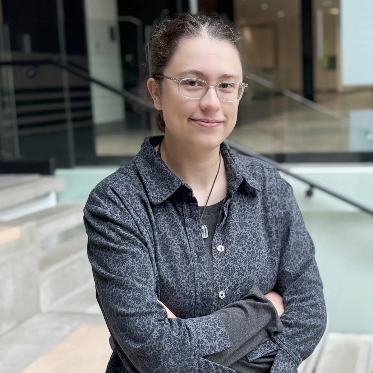 Professional woman in glasses showcasing Design, Works, and Engineering expertise at modern office