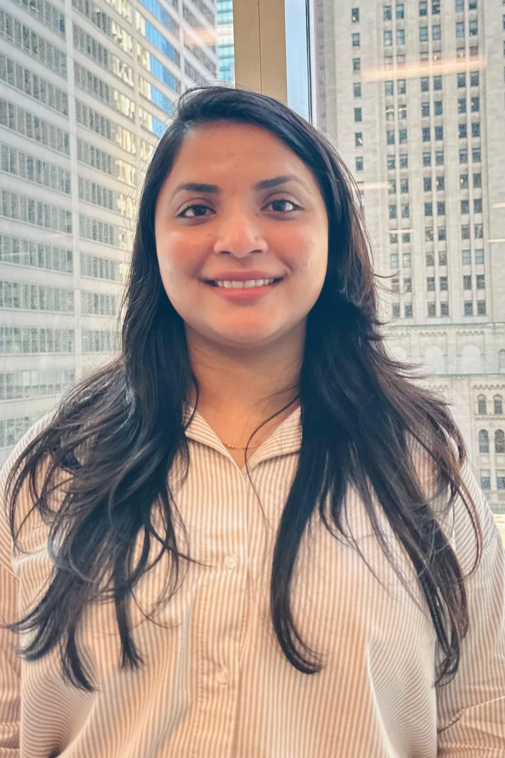 Professional woman smiling in modern office with Design, Works, Engineering background buildings