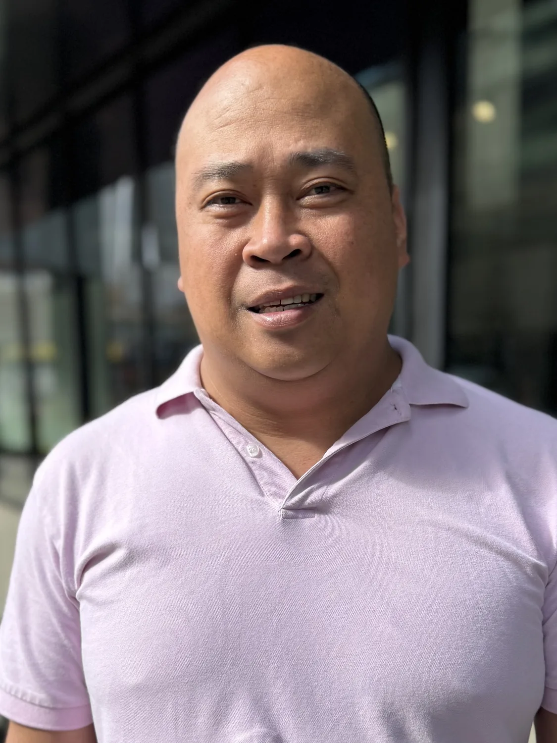 Professional headshot of man in pink polo shirt. Design, Works, Engineering expertise portrait.