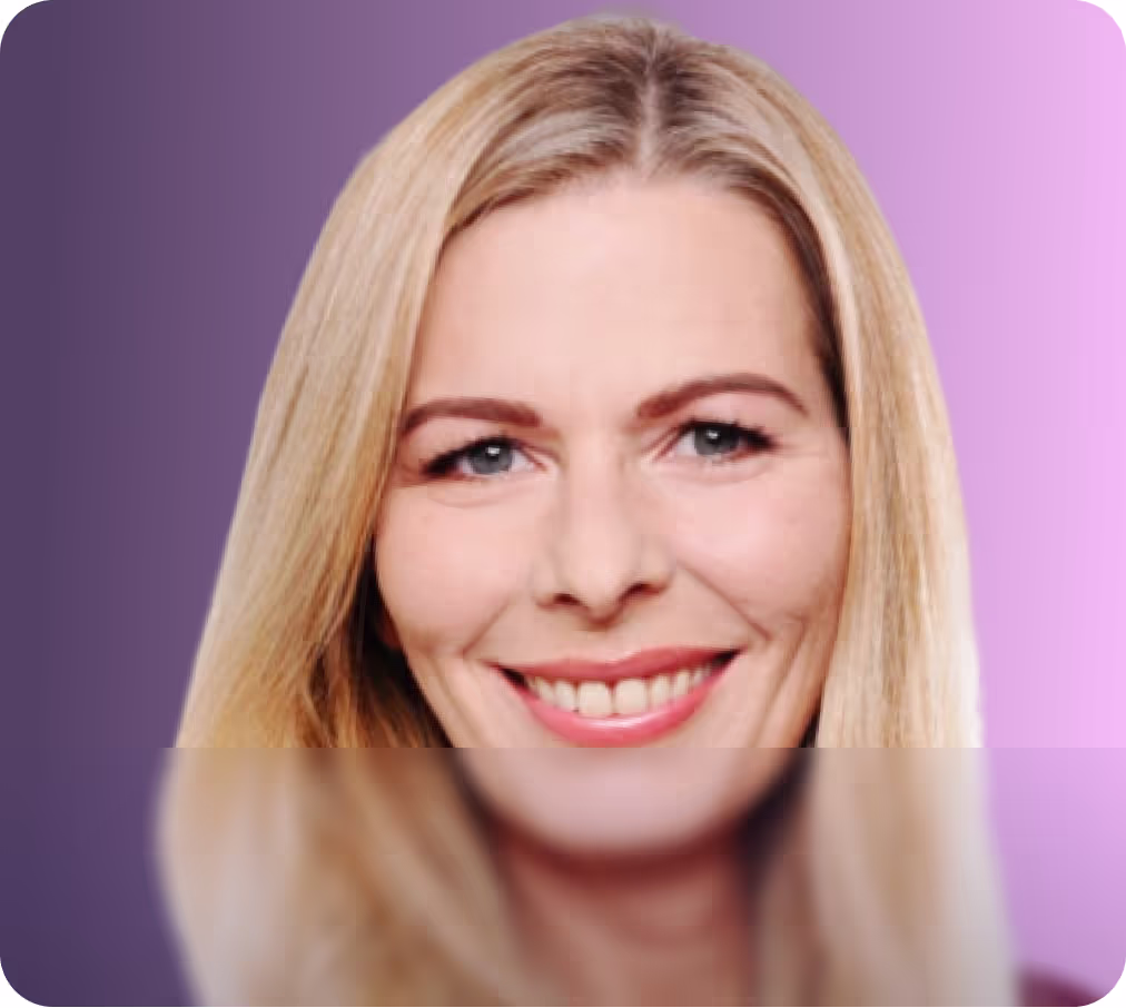 Freundlich lächelnde blonde Frau vor einem weich ausgeleuchteten rosa-violetten Hintergrund – professionelles Porträtfoto.