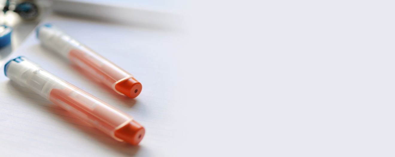 A photograph of two epi-pens on a desk