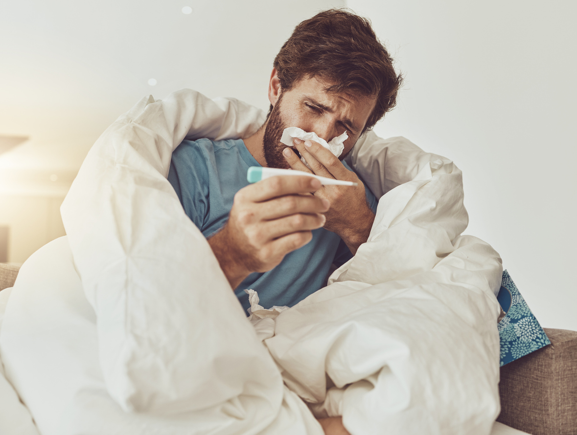 Person comparing a tissue box, medication bottles, and a thermometer at home