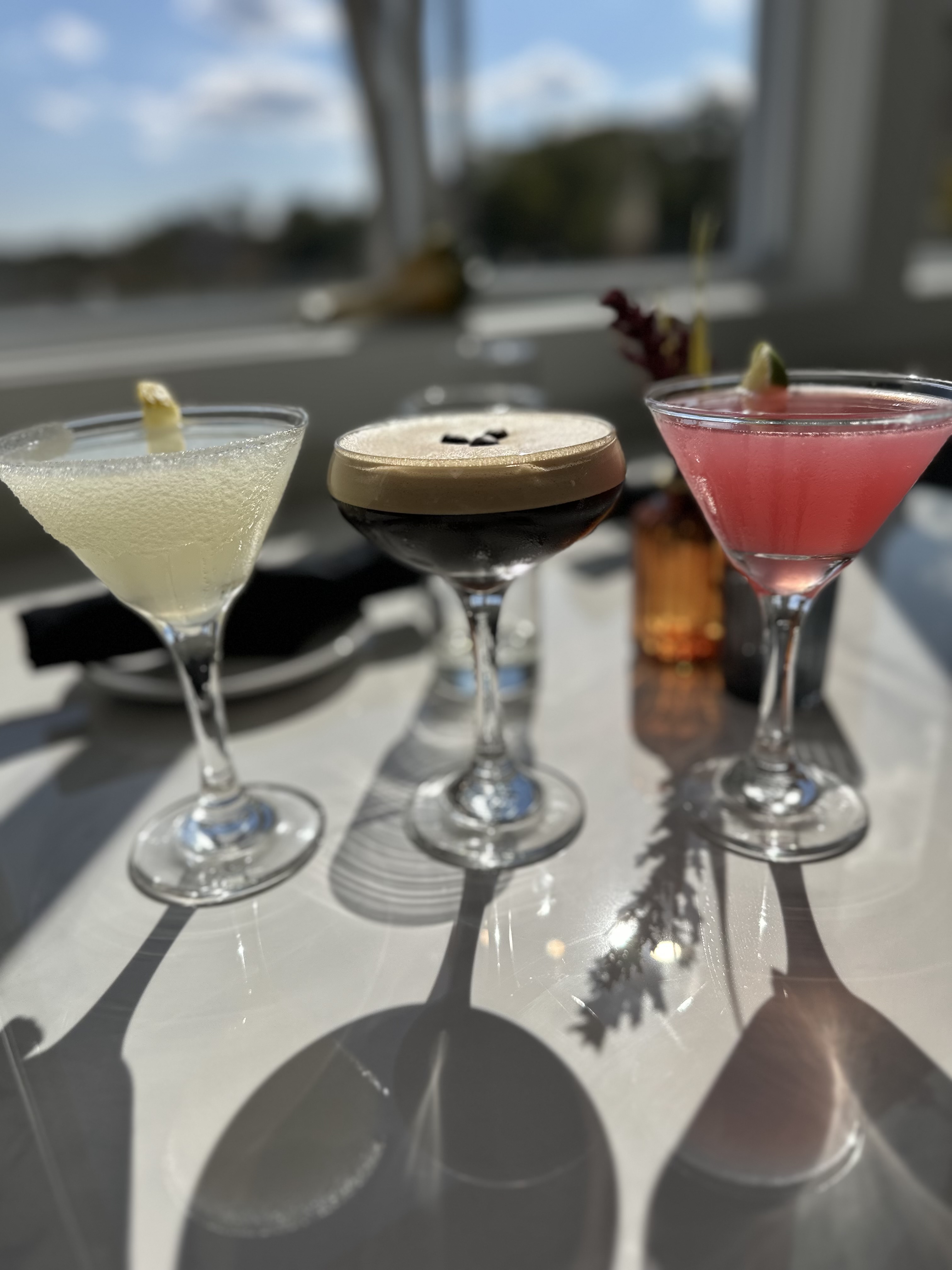 Three cocktails on dining table.