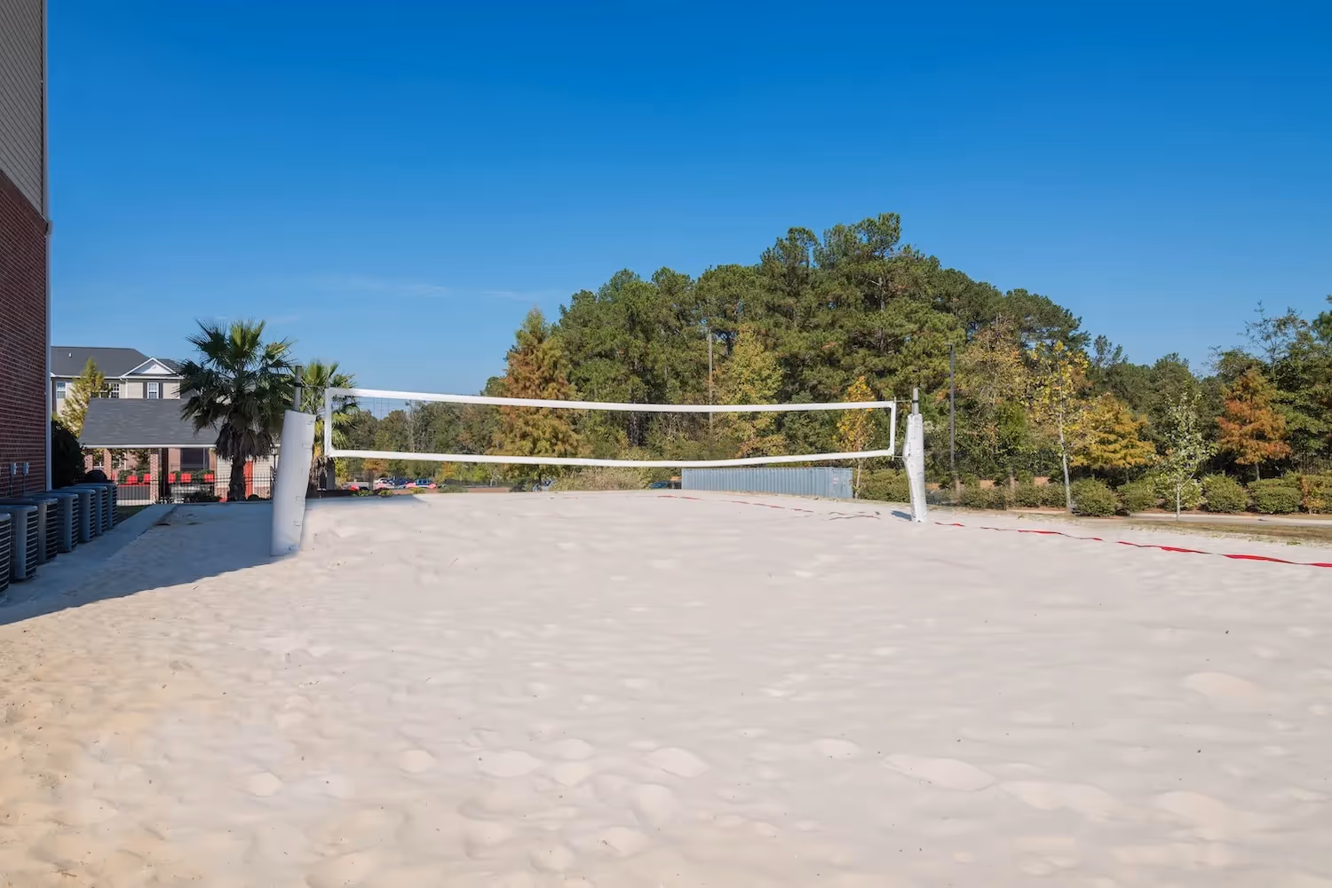 Outdoor sand volleyball court under a clear blue sky at The Grand at Lake Sheri in Valdosta, GA, perfect for resident recreation.