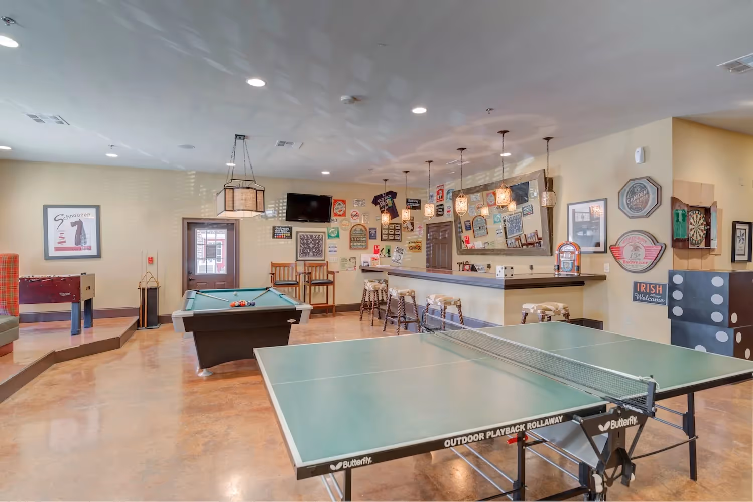 Spacious game room and common area at The Grand at Lake Sheri in Valdosta, GA, with a ping pong table, pool table, bar, and various entertainment options.