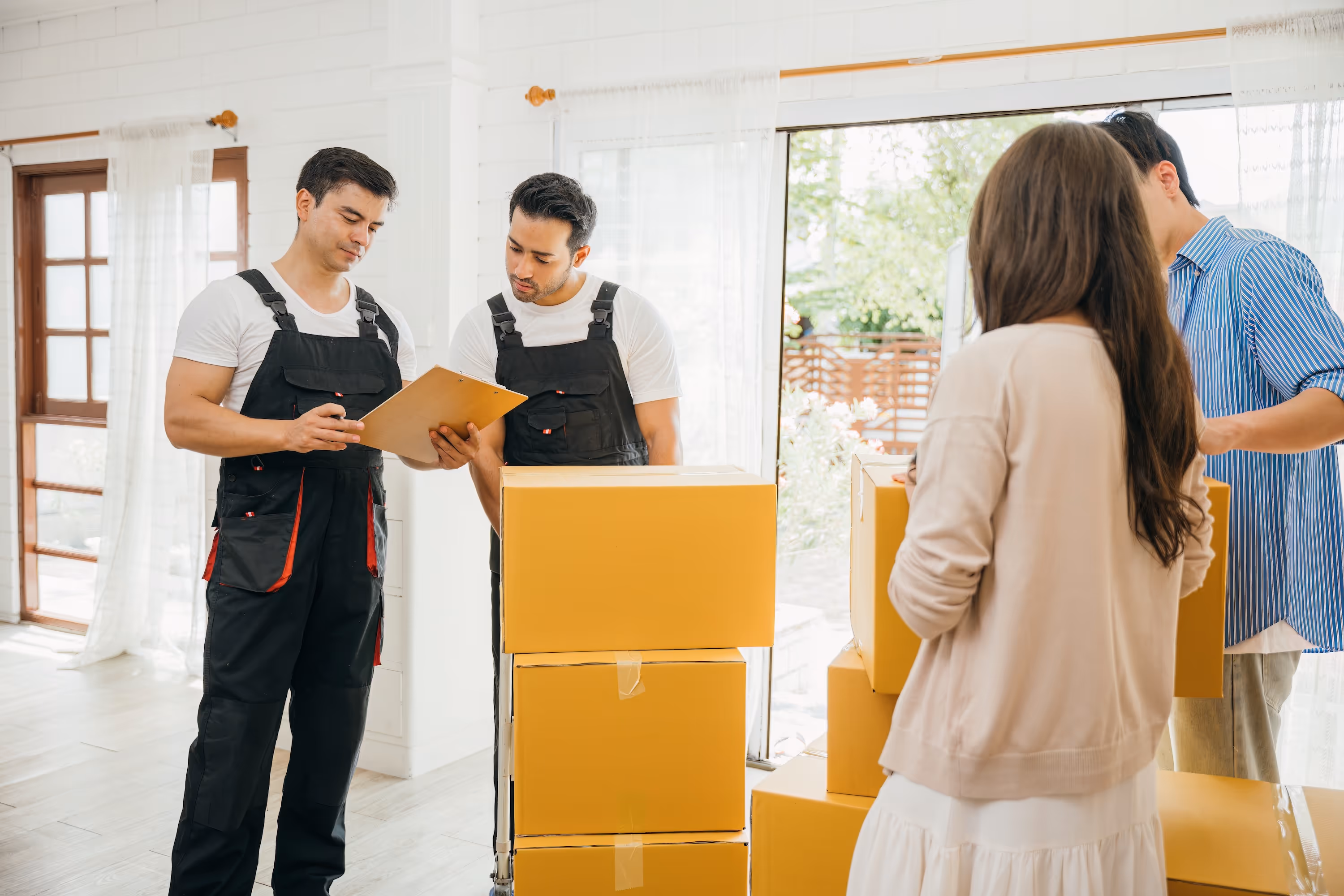 A couple speaking with movers who are carrying moving boxes, representing a smooth and easy move-in process for new residents at The Grand at Lake Sheri in Valdosta, GA.