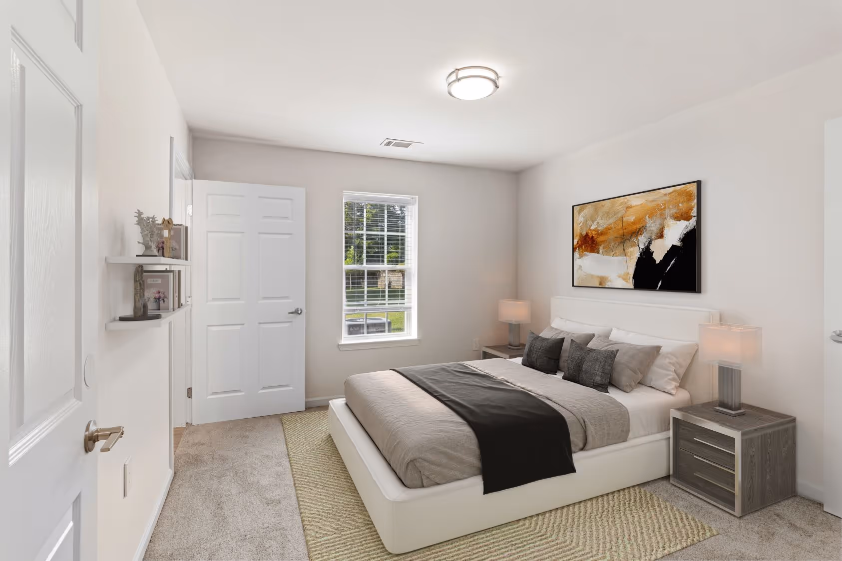 Spacious bedroom in an apartment at The Grand at Lake Sheri, Valdosta, GA, with carpet flooring, a ceiling fan, and an en-suite bathroom entrance.