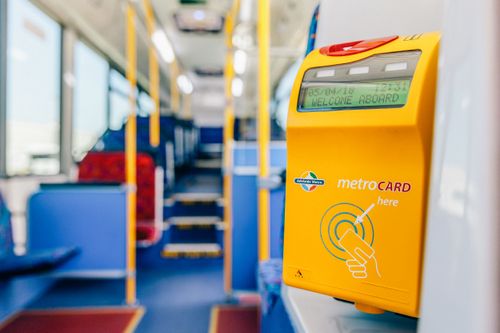 A yellow Metrocard reader inside an Adelaide Metro bus, displaying "WELCOME ABOARD".