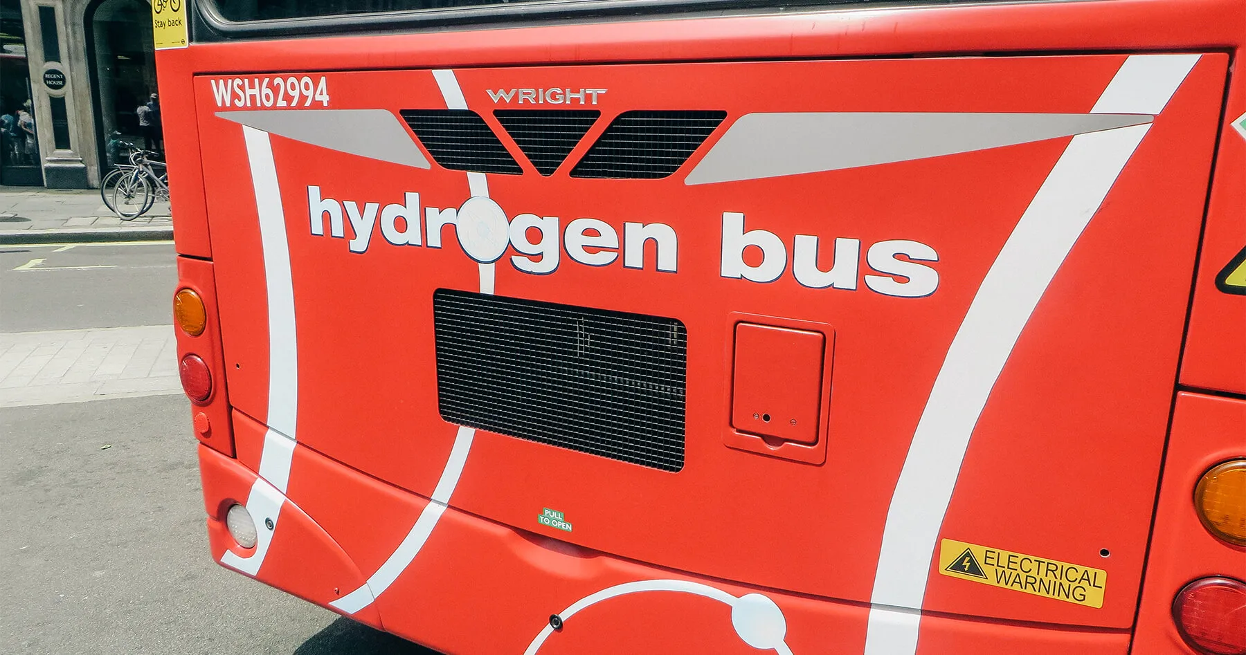 Rear view of a red "hydrogen bus" with white text.