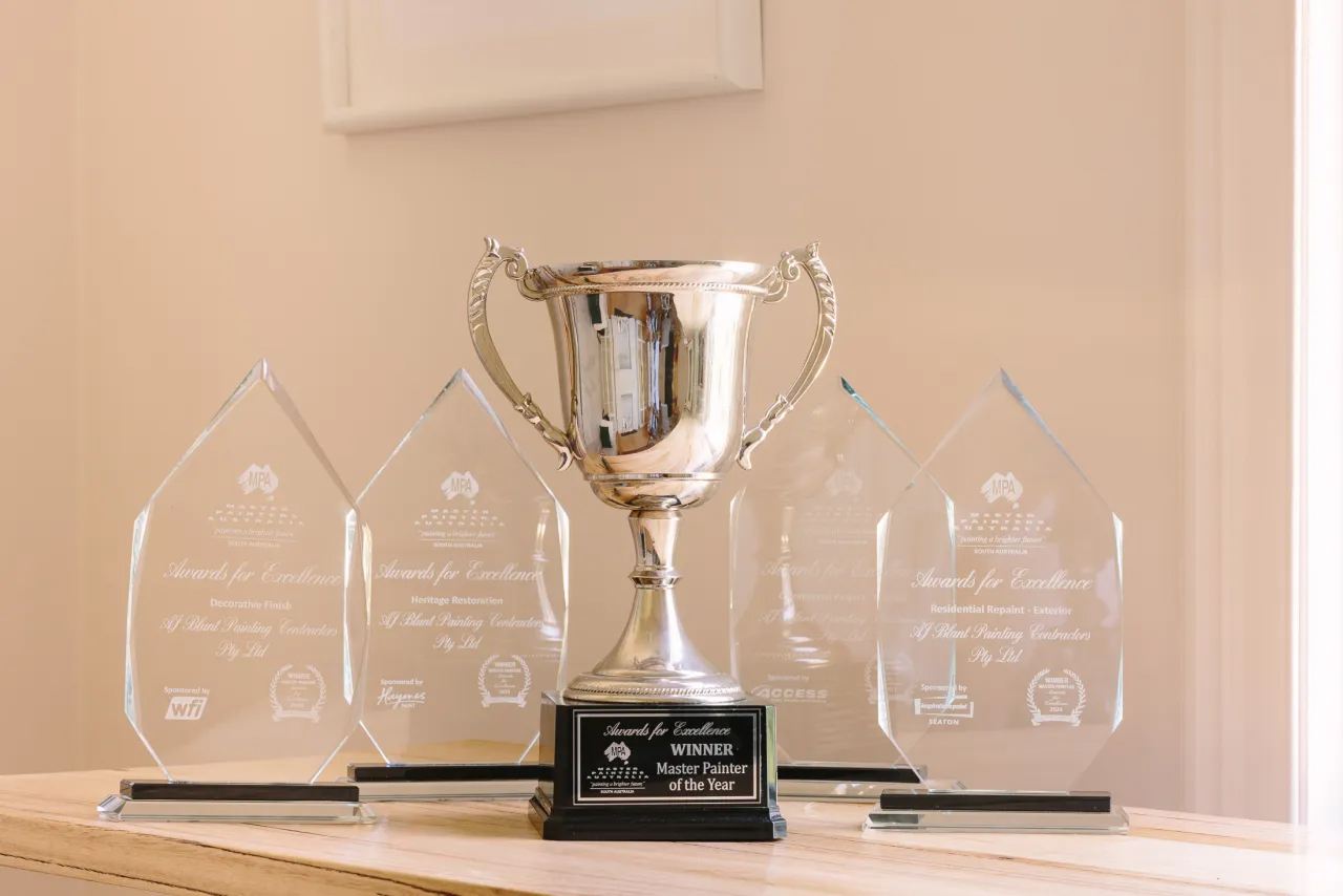 Master Painter of the Year trophy and four Awards for Excellence on a wooden table.