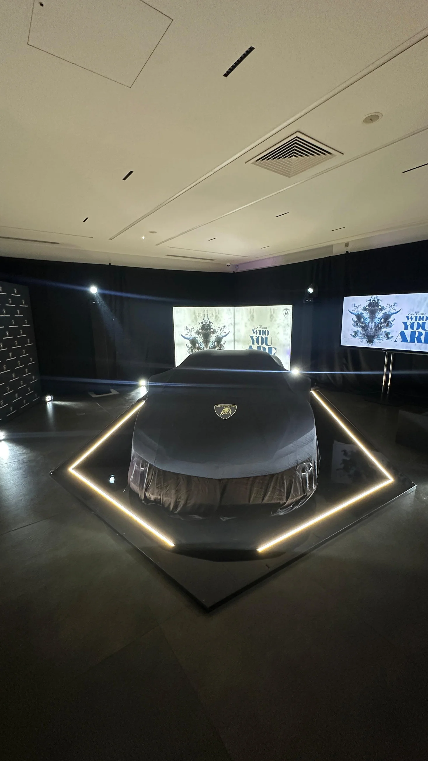 Covered presentation stage with lighting and LED screens in a dark venue