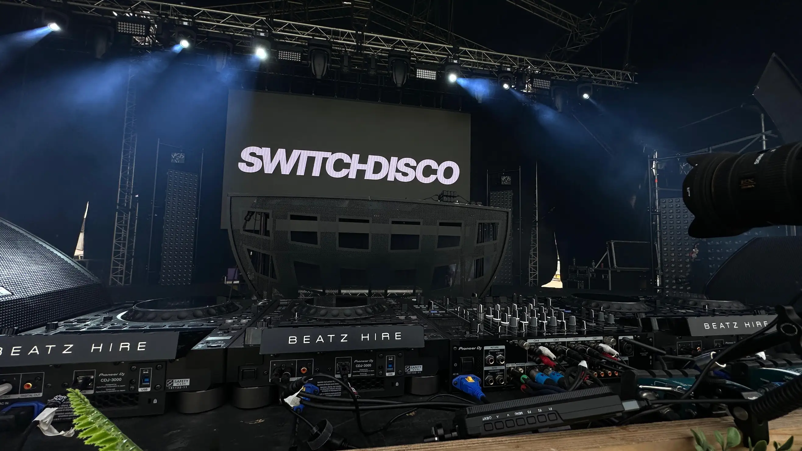 DJ stage setup with Pioneer equipment, speakers and a large LED screen