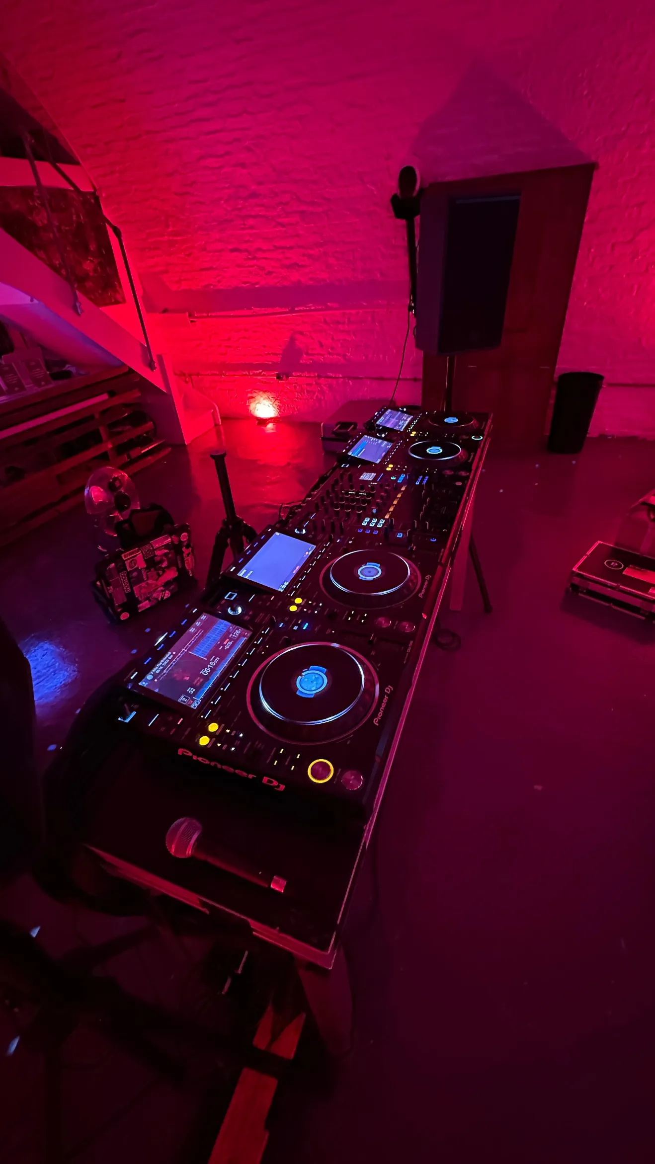 Professional Pioneer DJ equipment under pink and purple event lighting