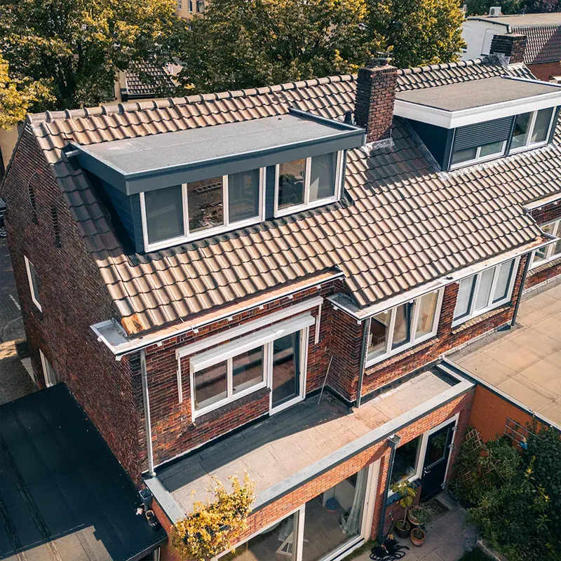 Luchtfoto van een woning met twee dakkapellen op het dak