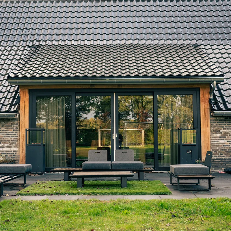 Antracieten kunststof schuifpui met houten accenten, geopend naar het terras
