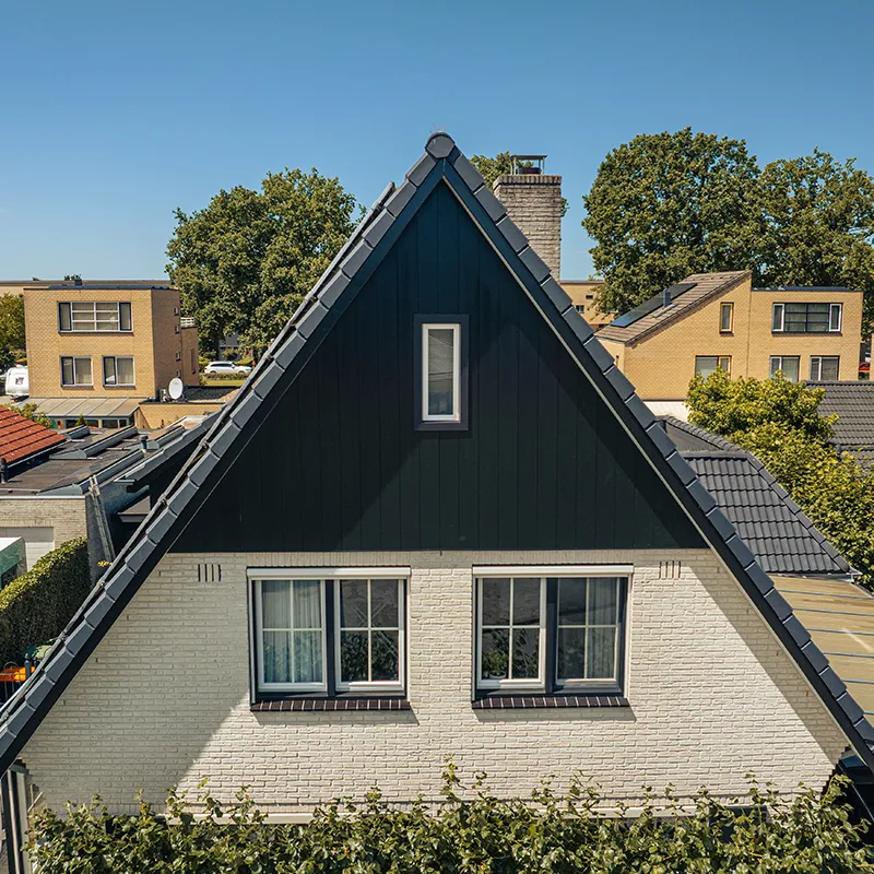 Antracieten Keralit gevelbekleding in de geveltop van een woning in een woonwijk
