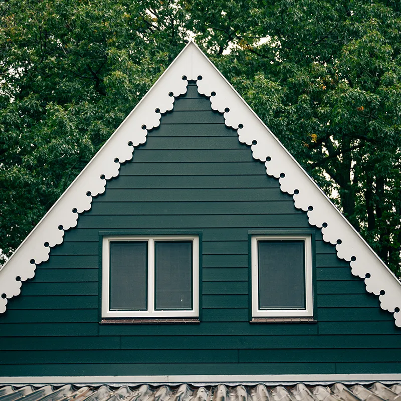 Groene Keralit gevelbekleding met witte sierlijst in de geveltop