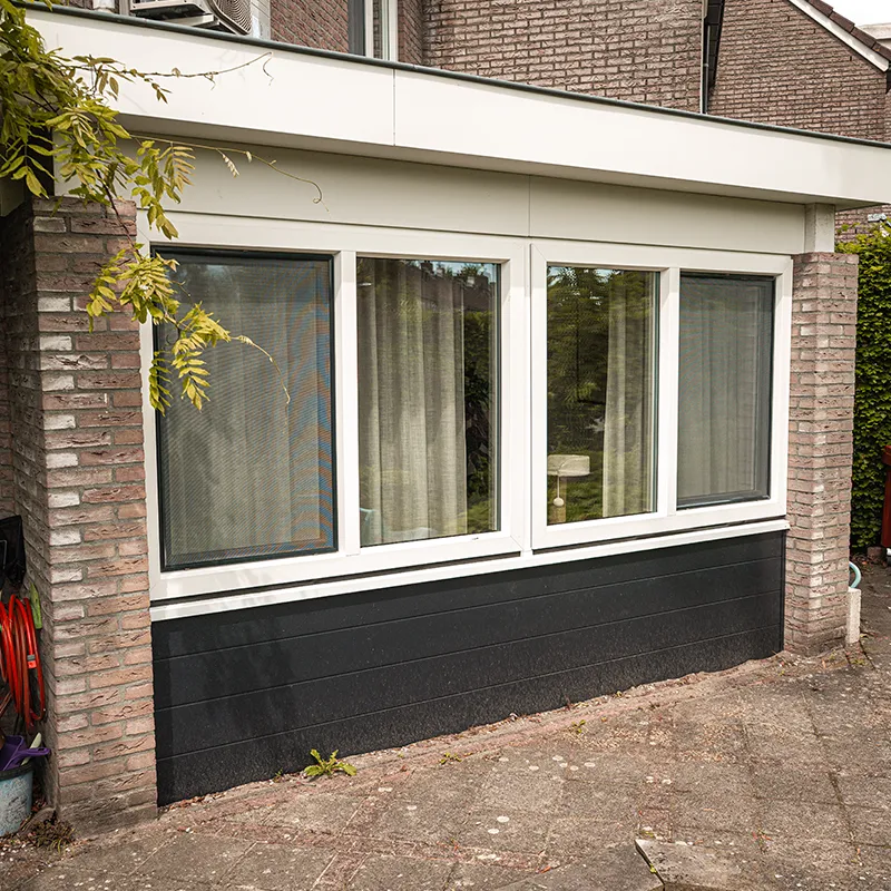 Uitbouw met witte kunststof kozijnen boven en antracietkleurige kunststof gevelbekleding onder, voorbeeld van een complete kozijnenrenovatie