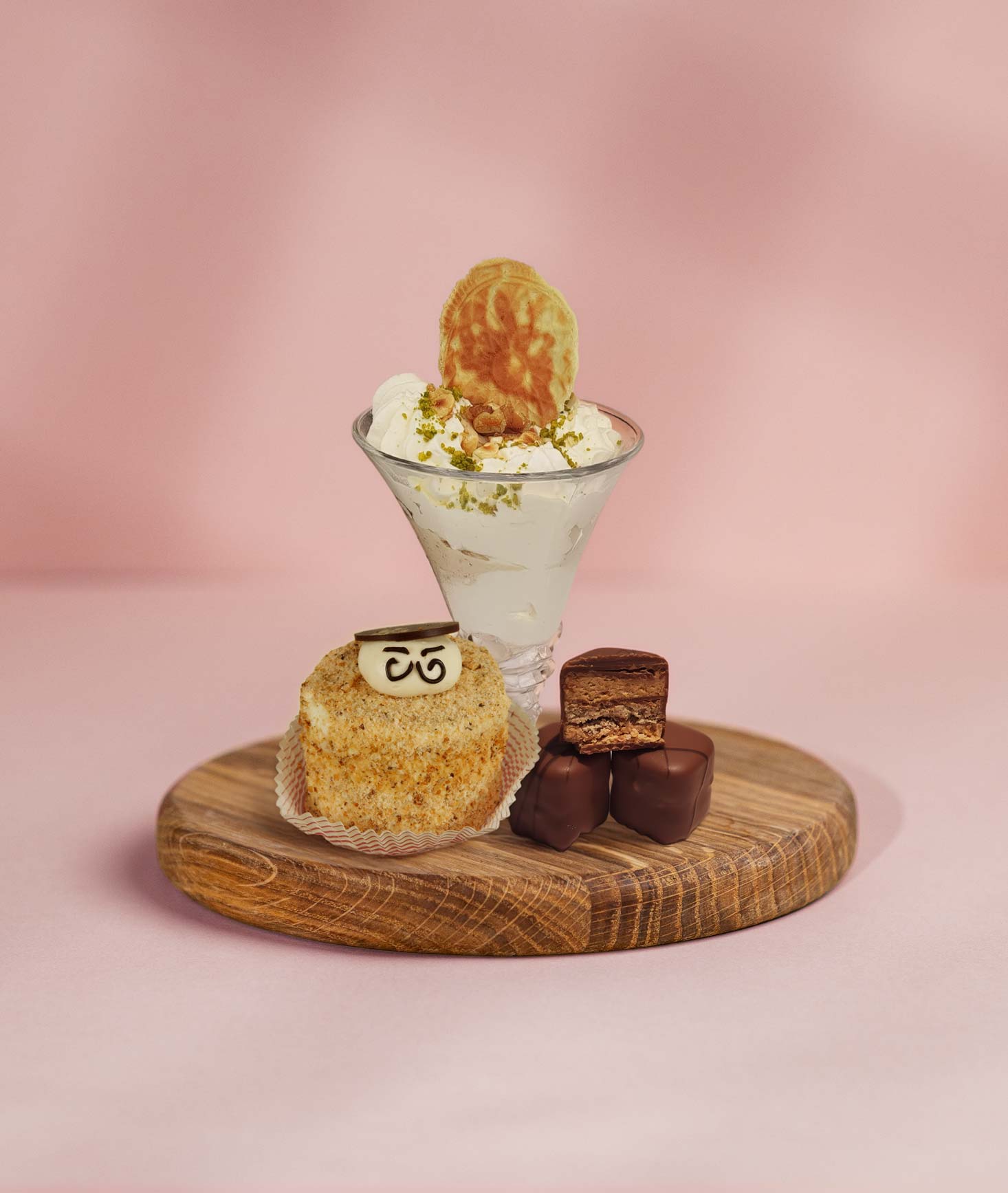 Eine Hand greift nach einer weißen Praline aus einer edlen Schachtel mit verschiedenen handgemachten Pralinen.