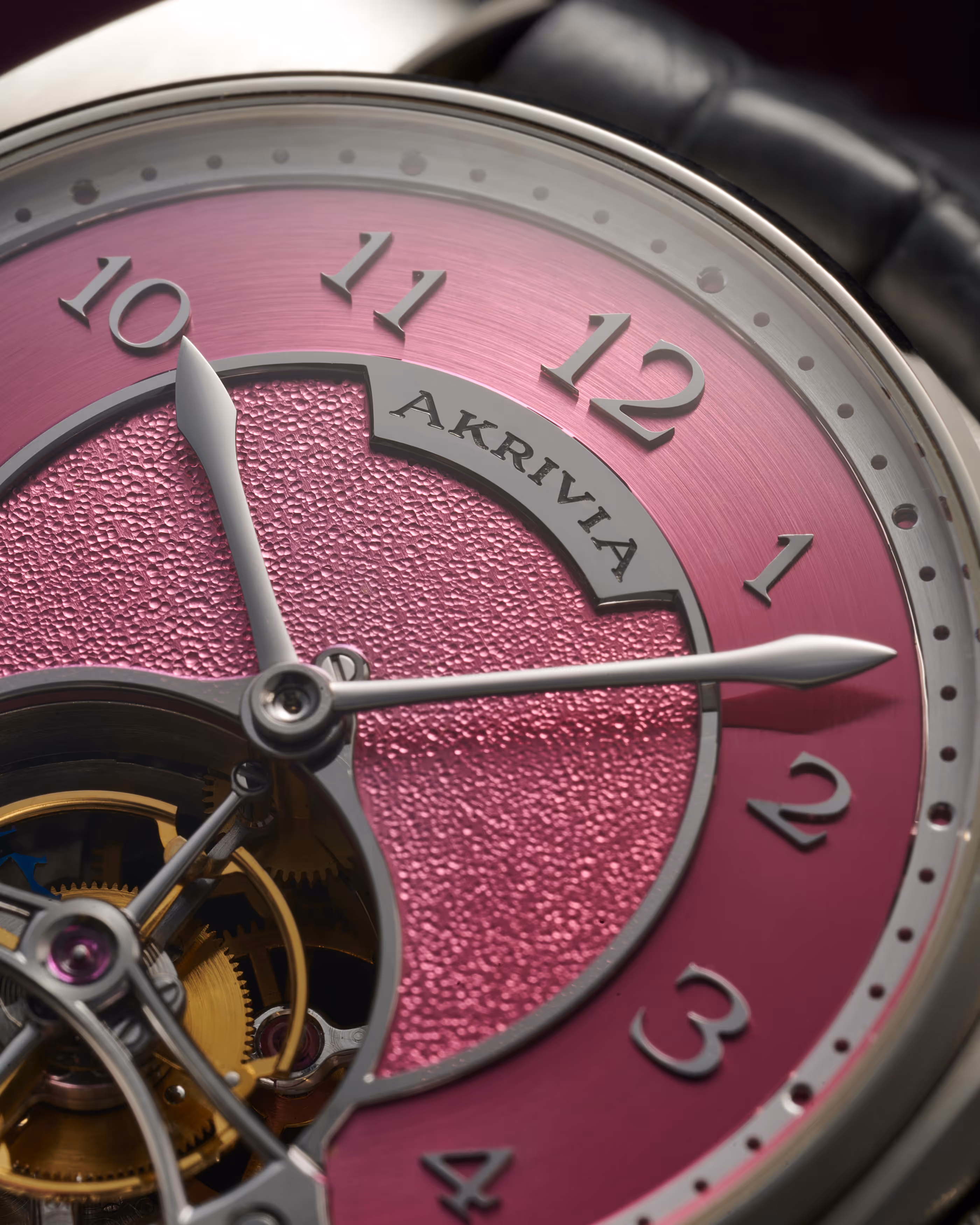 Detailed view of the hand-hammered pink dial and black-polished Arabic numerals of the AK-05 Akrivia