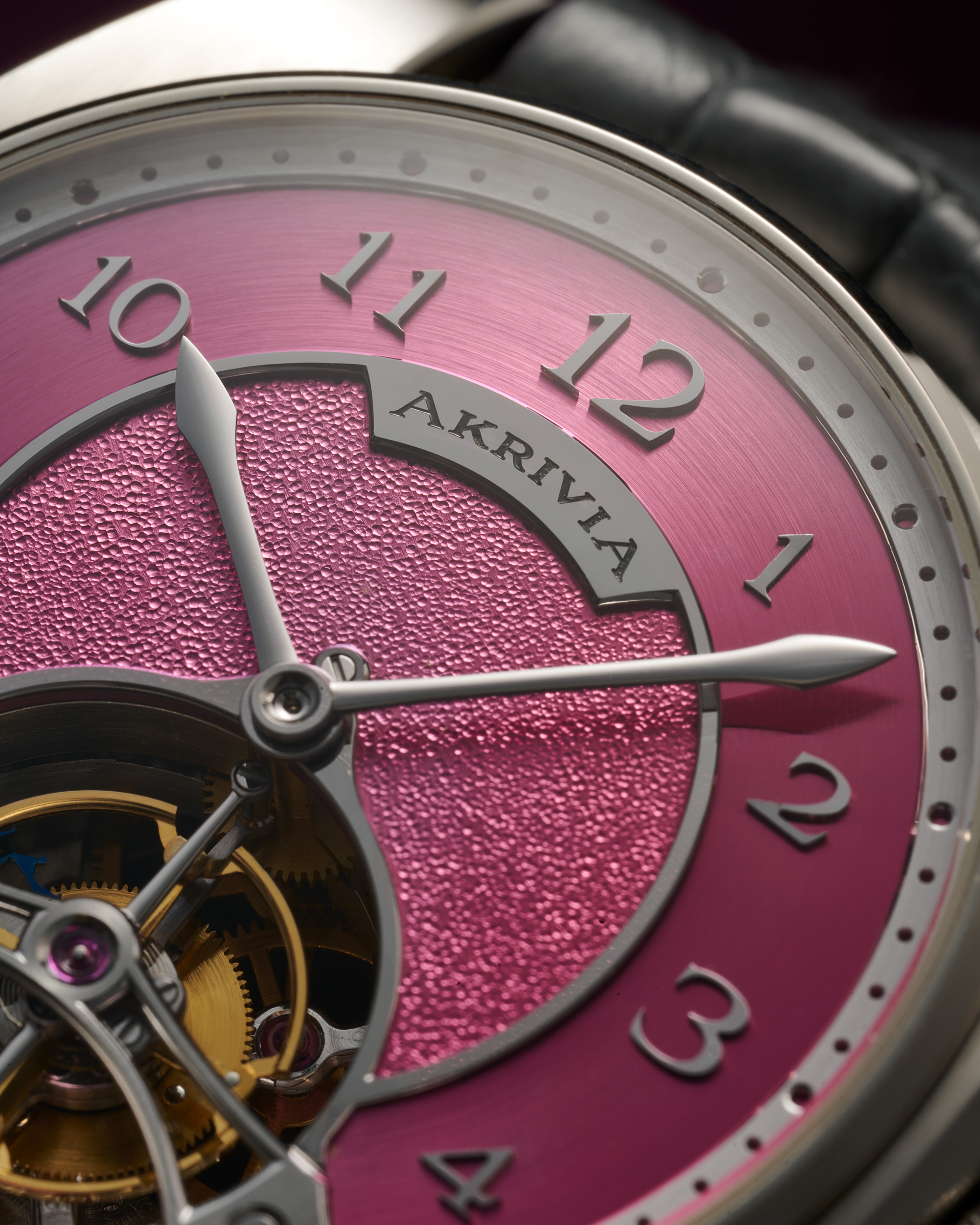 Detailed view of the hand-hammered pink dial and black-polished Arabic numerals of the AK-05 Akrivia