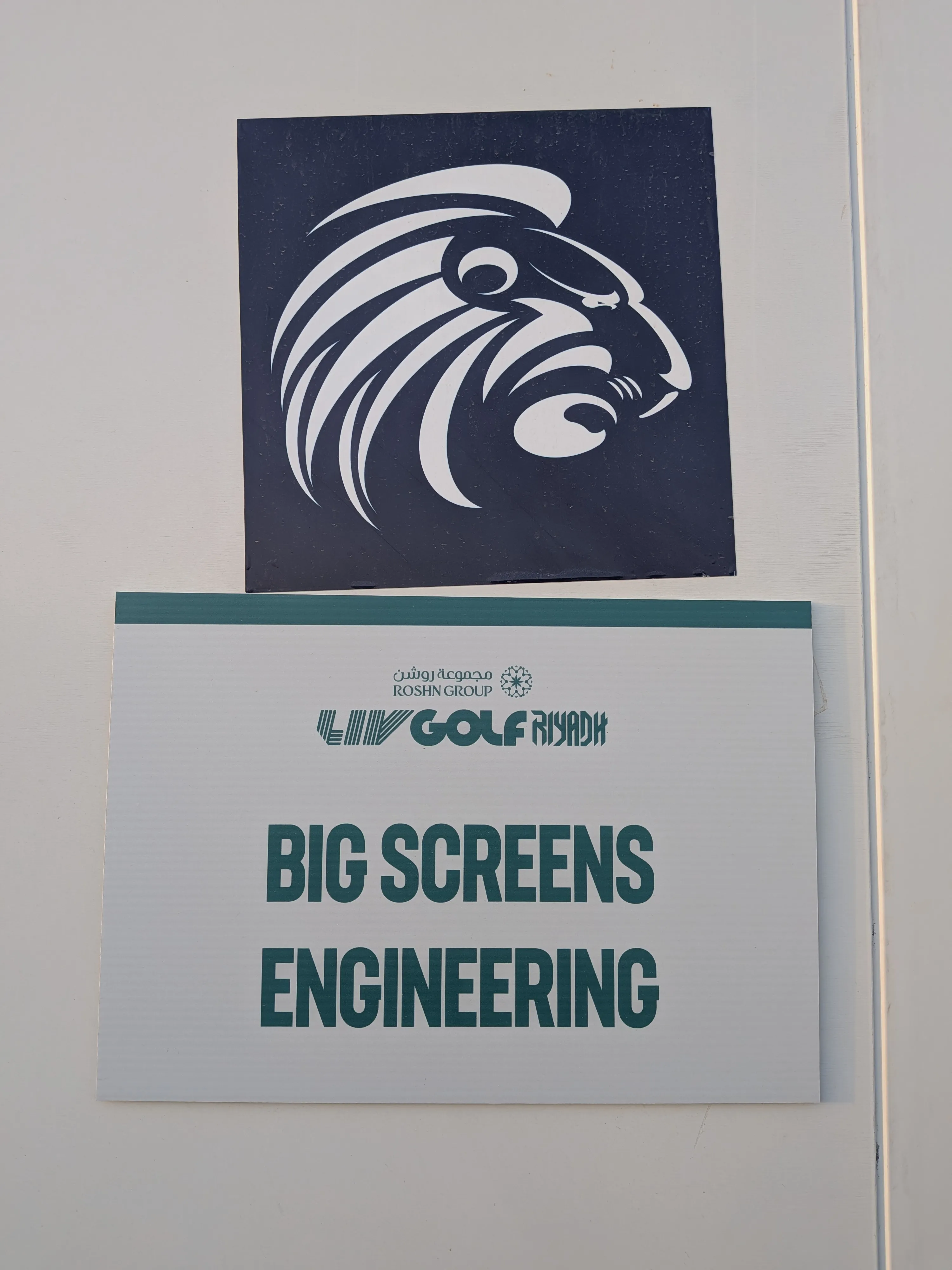 Sign with lion head logo above text reading 'LIV GOLF RIYADH' and 'BIG SCREENS ENGINEERING'.
