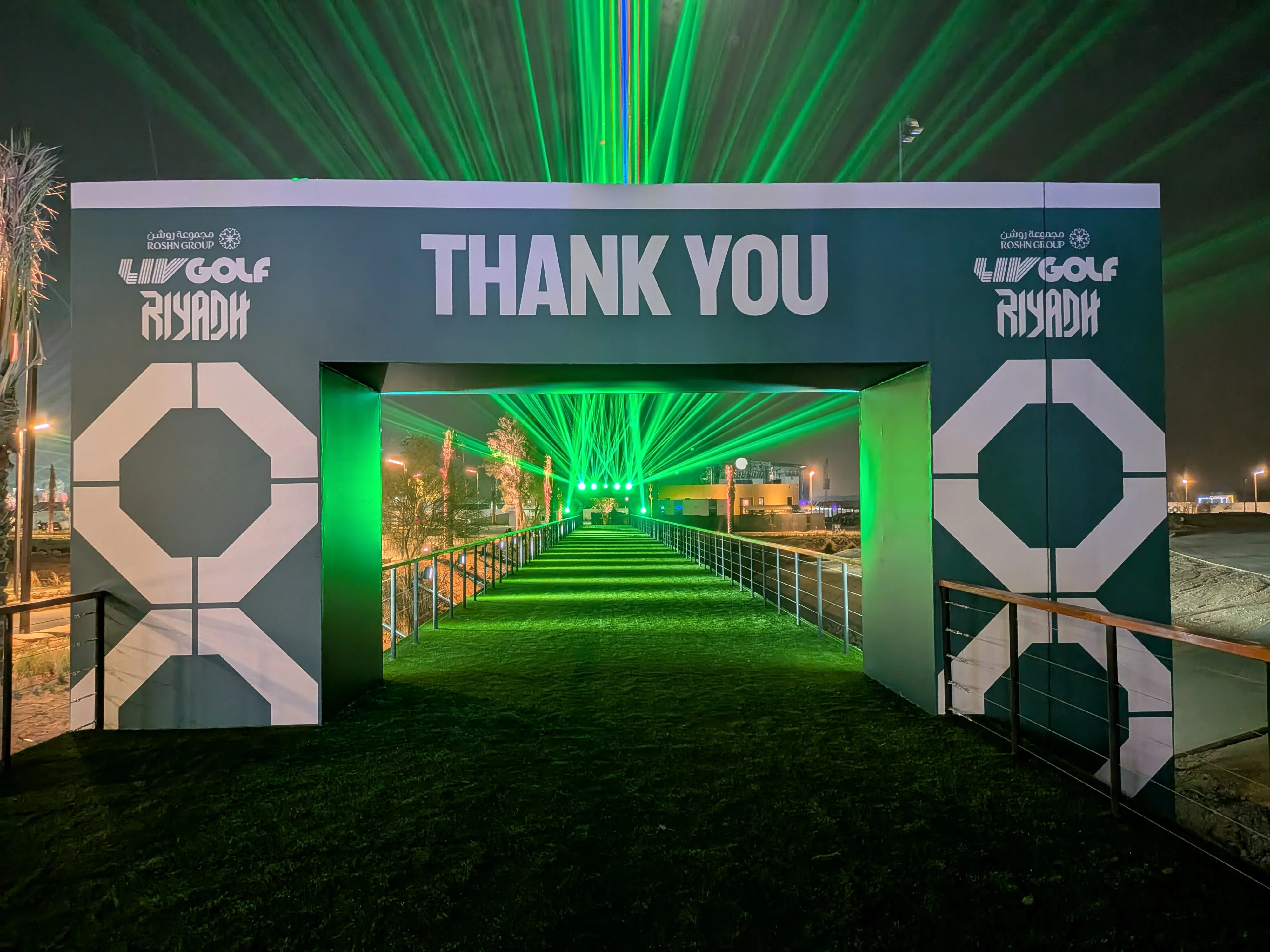 LIV Golf Riyadh night event entrance with green laser show and event branding.