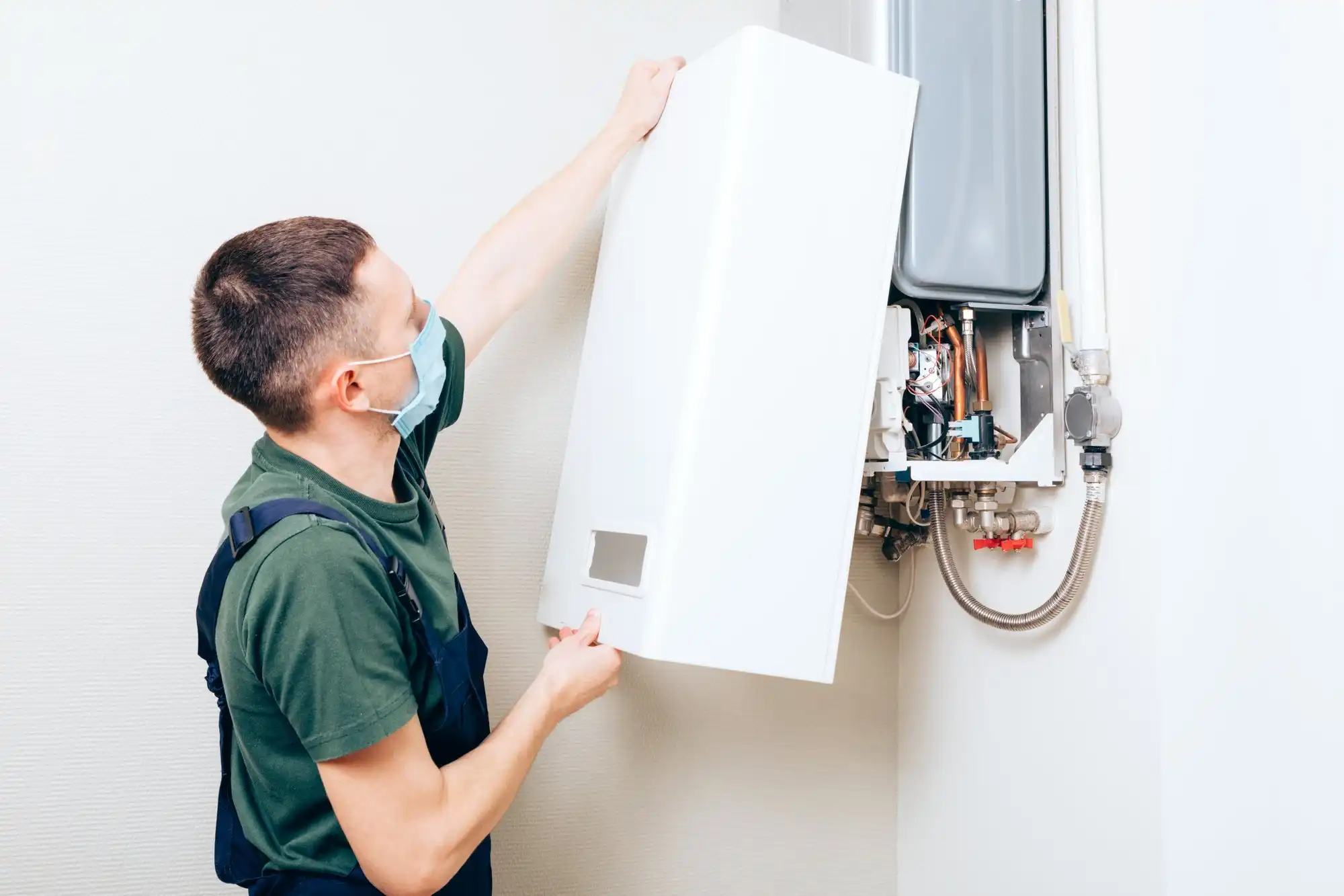 Technician installing cover on wall-mounted boiler.