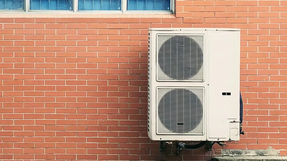 Outdoor mini-split AC unit on brick.